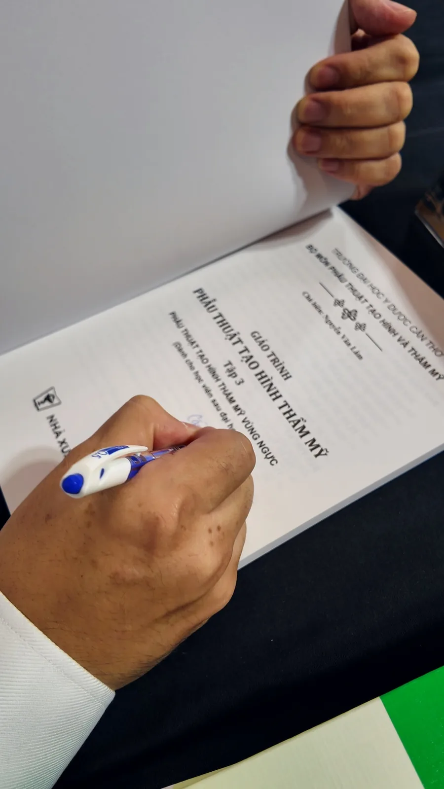 Dr. Kien signing a textbook